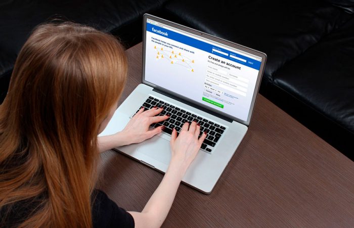 Mulher no computador entrando no Facebook